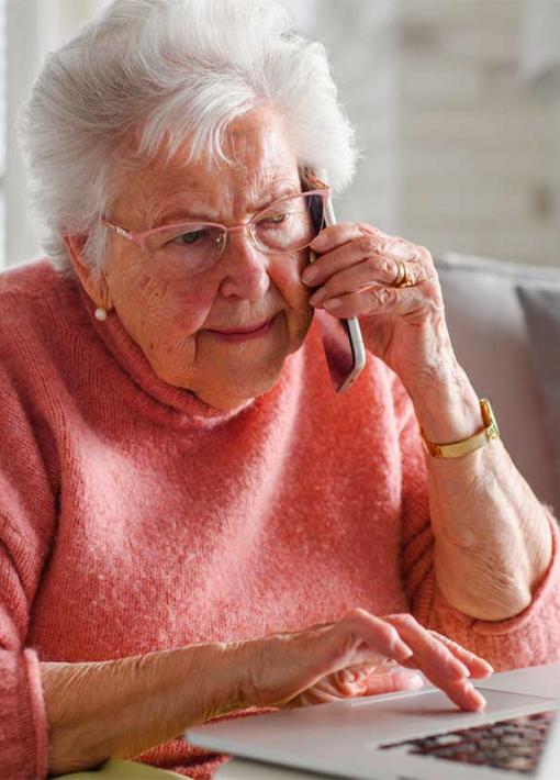 femme agée au téléphone devant son ordinateur